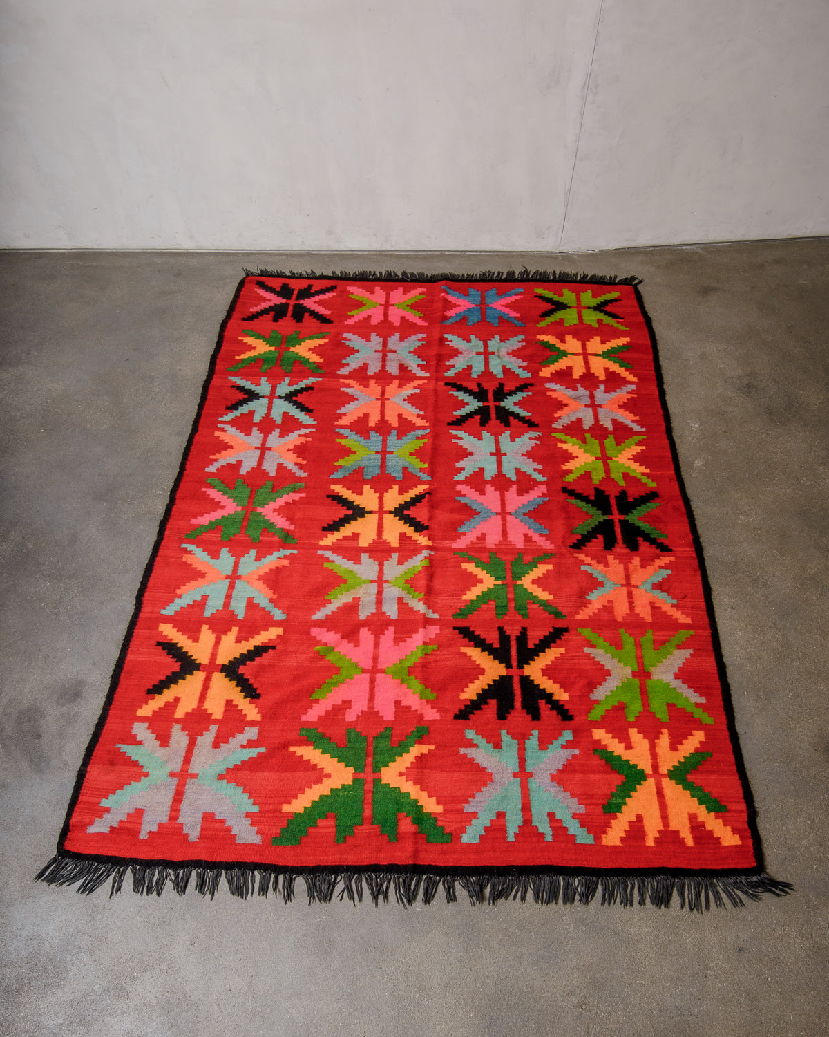Colorful geometric-patterned rug on a concrete floor